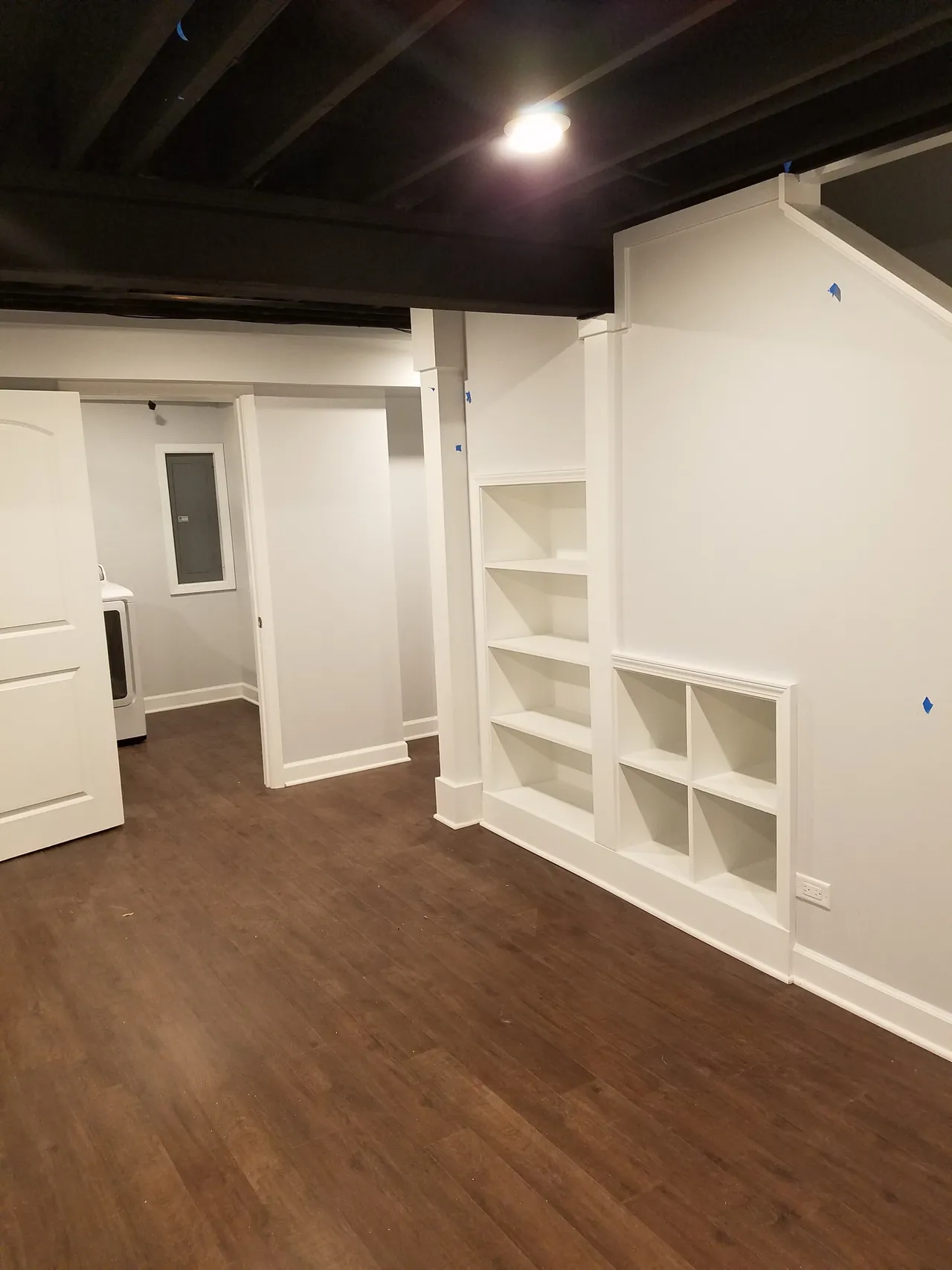 built-in shelving in basement remodel with hardwood flooring laminate 