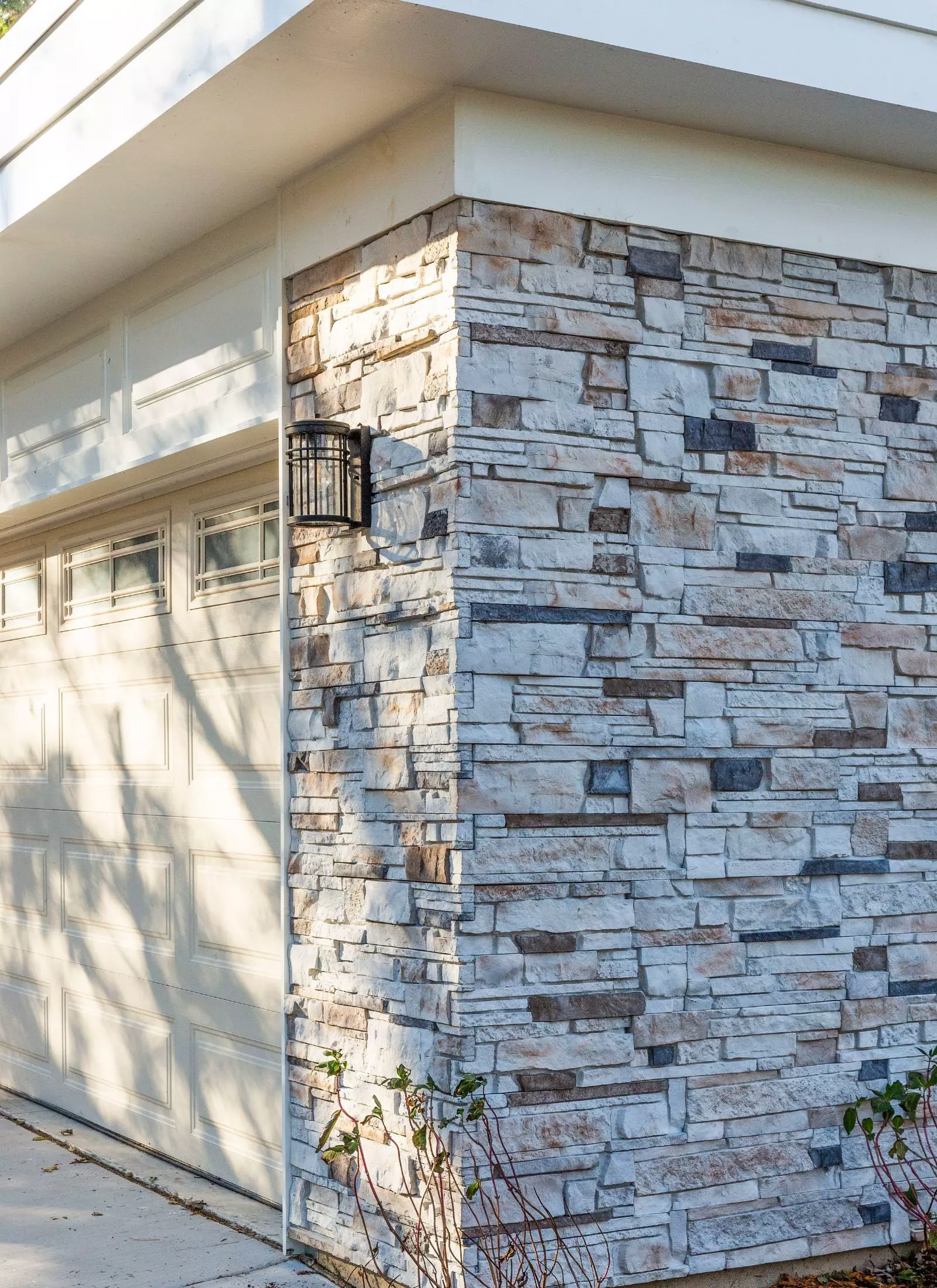A stone wall in front of a garage undergoing a home renovation.