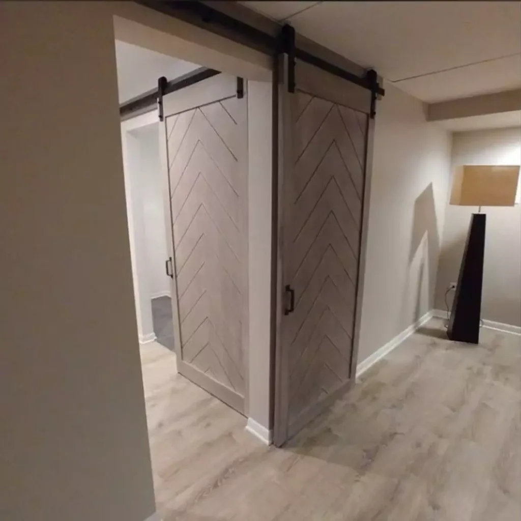 A sliding barn door in a kitchen remodel with hardwood floors.