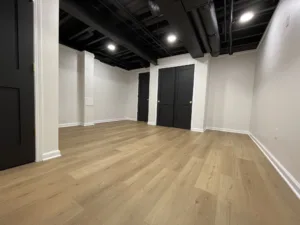 An empty room with wood floors and black walls.