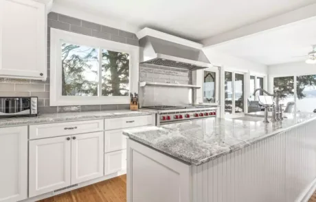 A kitchen with white cabinets and granite counter tops.