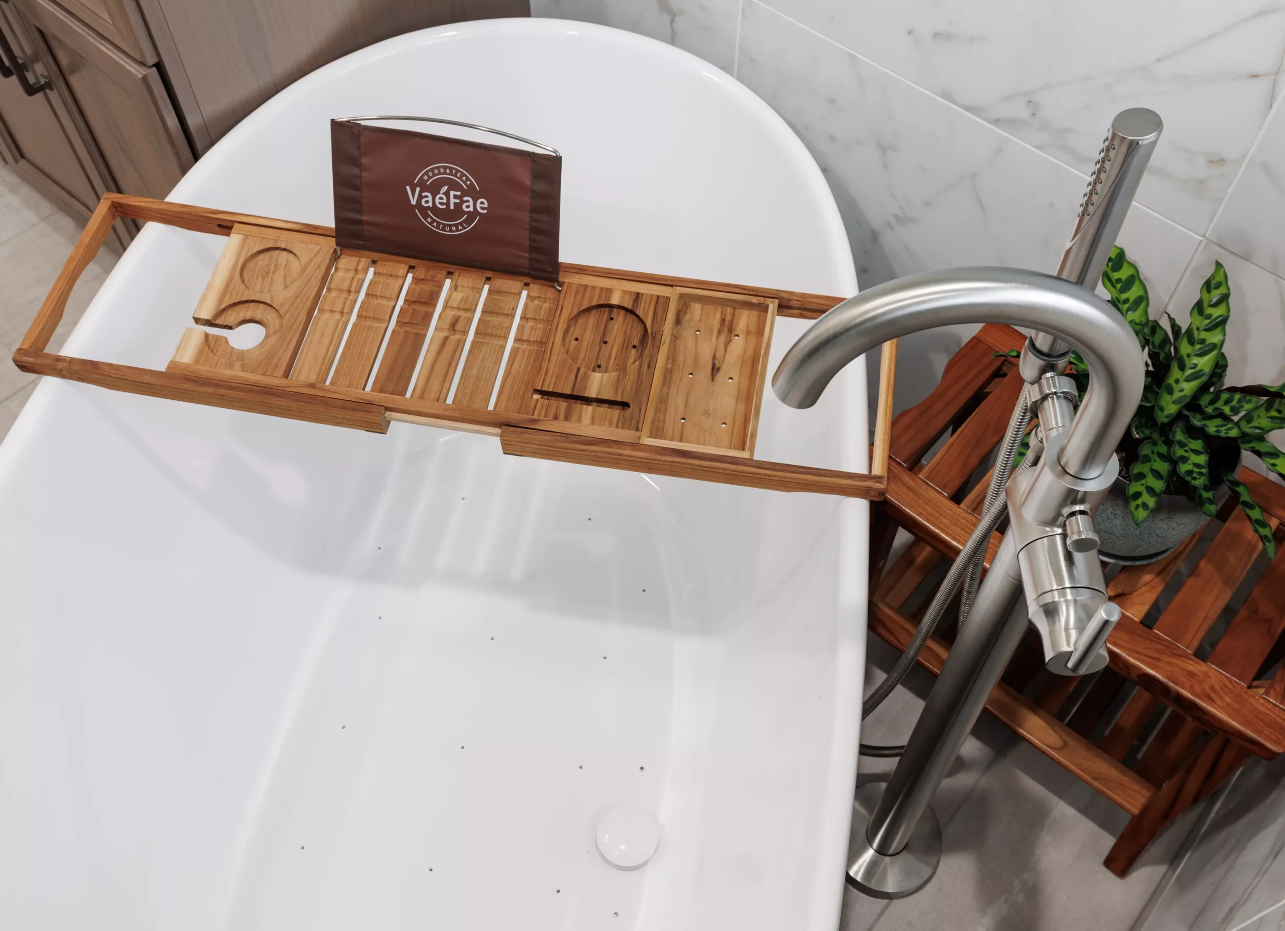 A bathroom with a wooden tub holder and a plant, perfect for a home renovation or bathroom remodel.